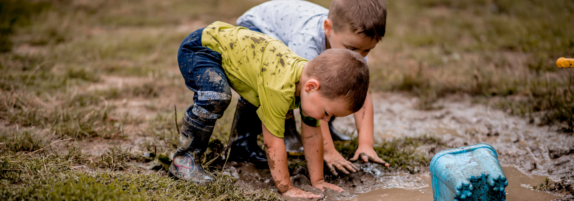 Two boys play in the mud.